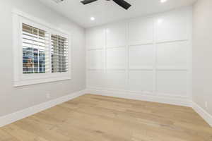 Empty room with light wood-style flooring, a decorative wall, recessed lighting, and ceiling fan