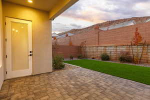 Patio terrace at dusk with a patio and a fenced backyard