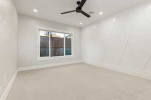 Unfurnished room with carpet, recessed lighting, a ceiling fan, and a decorative wall