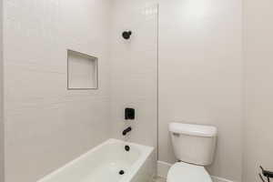 Bathroom featuring washtub / shower combination and toilet