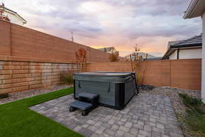 Fenced backyard featuring a patio and a hot tub