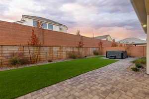 Fenced backyard featuring a hot tub and a patio area
