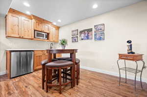 Kitchen with light countertops, stainless steel appliances, light brown cabinetry, light wood finished floors, and recessed lighting