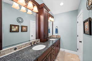 Full bathroom with double vanity and light tile patterned floors