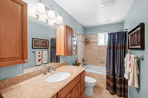 Full bathroom featuring tiled shower / bath combo, vanity, and light tile patterned flooring