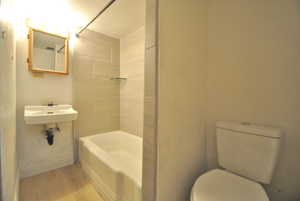 Full bathroom with tub / shower combination and light wood finished floors