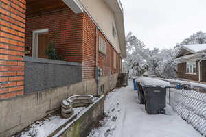 Snow covered property featuring brick siding
