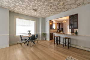 Dining space with light wood-style flooring, baseboard heating, and a chandelier