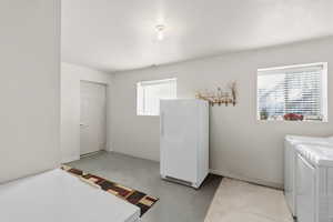 Washroom featuring washing machine and clothes dryer and concrete floors