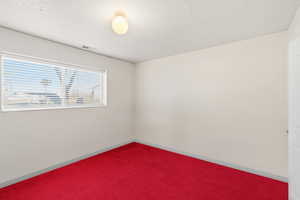 Spare room with a textured ceiling and carpet