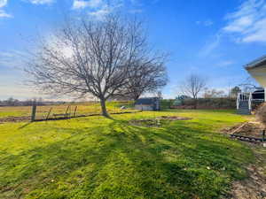 View of green lawn featuring an outbuilding