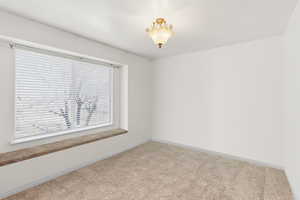 Carpeted empty room featuring baseboards