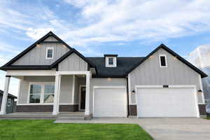 Modern farmhouse style home featuring board and batten siding, concrete driveway, covered porch, a garage, and a front yard