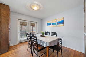 Dining space with a textured ceiling and light wood-style flooring