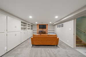 Carpeted living area with recessed lighting, stairway, and built in shelves