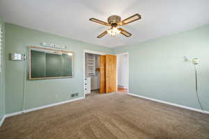 Unfurnished bedroom featuring carpet flooring and ceiling fan