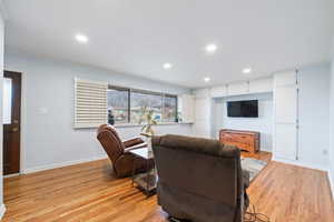 Living area featuring light wood-type flooring, recessed lighting, and crown molding