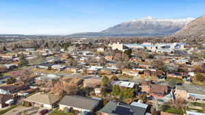 Aerial view of property's location with nearby suburban area and a mountainous background