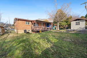 Rear view of house with a wooden deck and brick siding