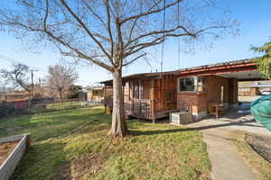 Rear view of property featuring brick siding and a deck
