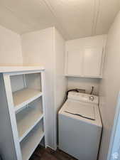 Laundry room featuring washer / dryer, a textured ceiling, and dark wood-type flooring