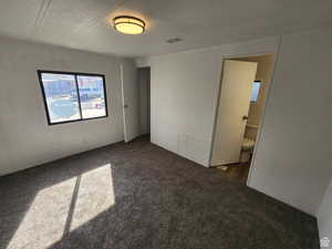 Unfurnished room with dark carpet