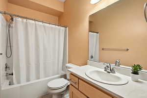 Full bath with shower / bath combination with curtain and vanity