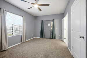 Empty room featuring light carpet and ceiling fan