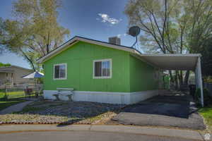 View of property exterior with driveway and a carport