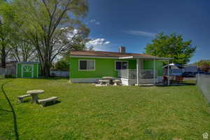 Rear view of house featuring a fenced backyard, a shed, and a patio area