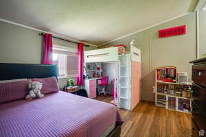 Bedroom featuring dark wood finished floors, ornamental molding, and a textured ceiling