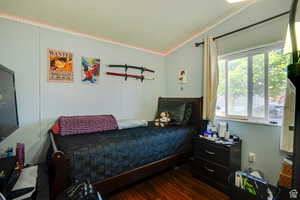 Bedroom with dark wood-style flooring and ornamental molding