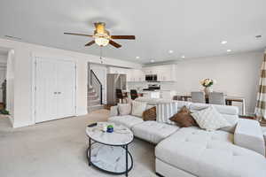 Living area featuring stairway, recessed lighting, light colored carpet, and ceiling fan