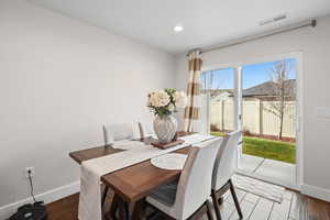 Dining area featuring dark wood-type flooring and recessed lighting