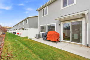 Rear view of house with stucco siding and a patio area