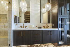 Bathroom featuring double vanity and a shower stall