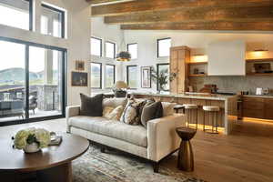 Living area featuring light wood-type flooring, beam ceiling, and high vaulted ceiling
