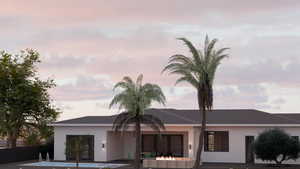 View of front of property with a patio, stucco siding, and roof with shingles