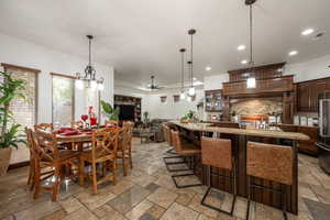 Dining room featuring a ceiling fan, recessed lighting, and stone tile floors