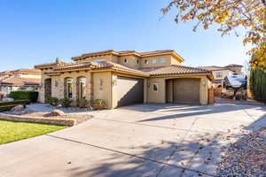 Mediterranean / spanish home with stucco siding, concrete driveway, an attached garage, and a tile roof