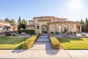 Mediterranean / spanish home with stucco siding, a tile roof, and stone siding