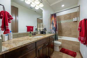 Full bath featuring vanity, tiled shower / bath, and light tile patterned floors