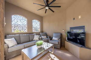 Living room with ceiling fan and tile patterned floors