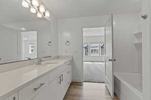 Full bath with vanity, light wood finished floors, and light carpet