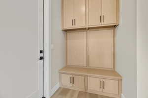 Mudroom with light wood-style floors and baseboards