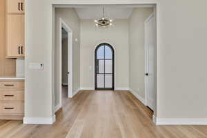 Foyer entrance featuring a chandelier and light wood-style floors