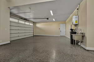 Garage featuring baseboards and water heater