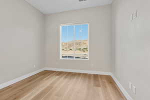 Spare room with baseboards and light wood-style flooring
