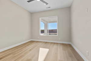 Spare room featuring baseboards and light wood-type flooring