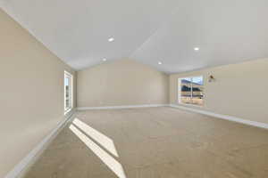 Empty room featuring healthy amount of natural light and lofted ceiling